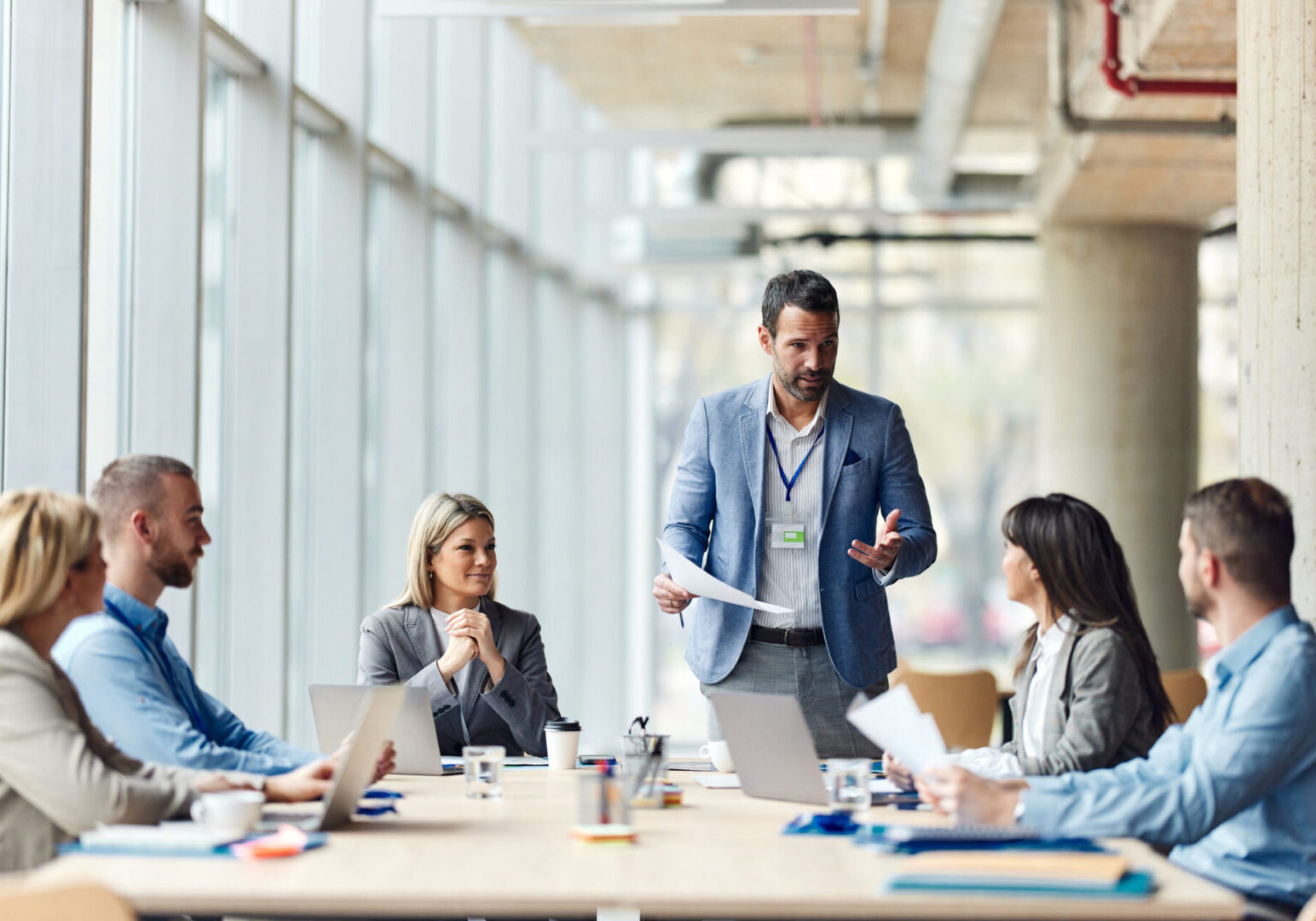 Mid adult male CEO communicating with group of his colleagues during a meeting in the office.